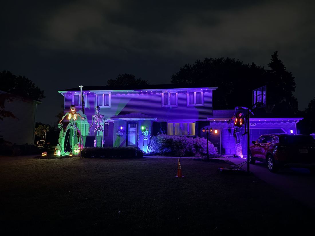 Buffalo, first night. A house in the neighborhood already all in on Halloween: giant skeletons, a pumpkin-headed figure, purple and green lights.
