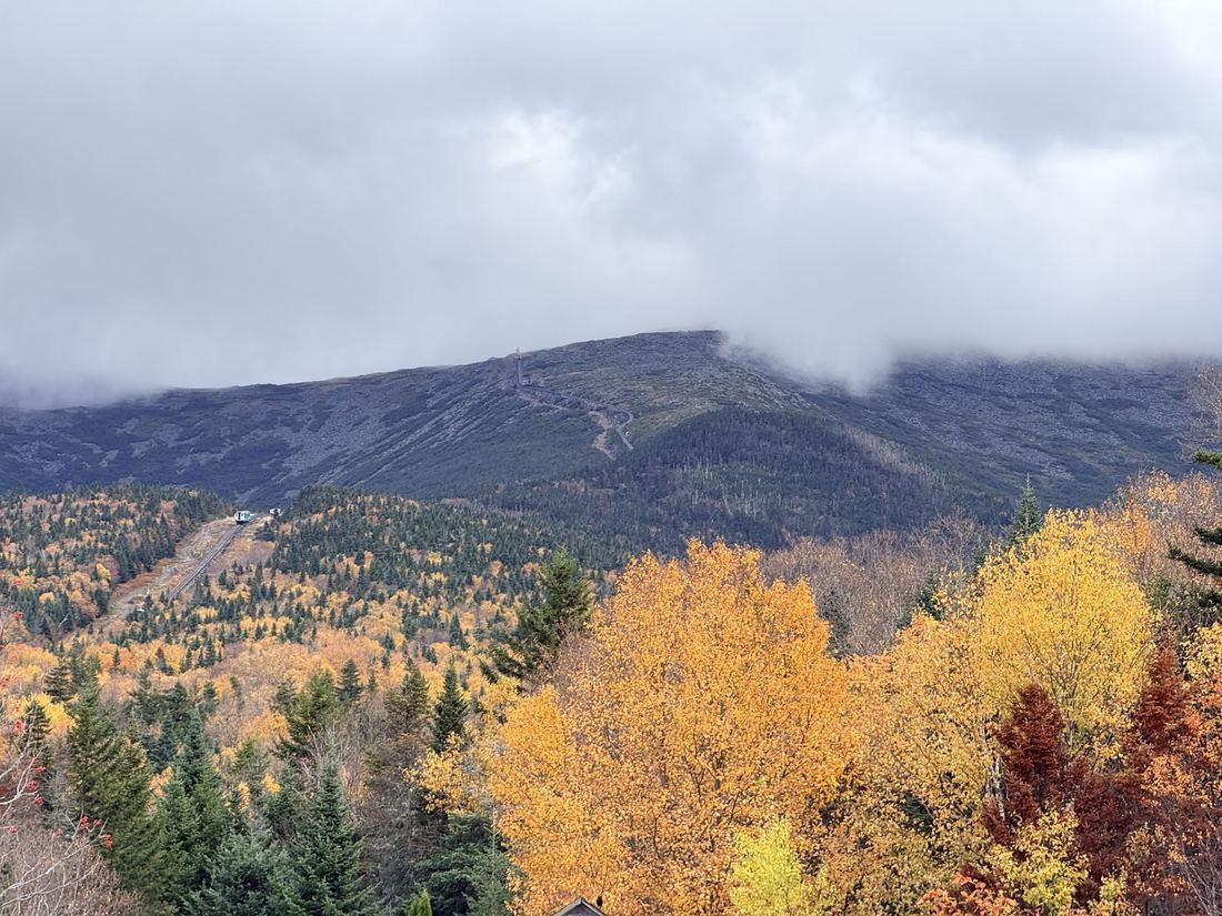 Mount Washington. The Cog Railway line climbing into the clouds, with a train on the track.
